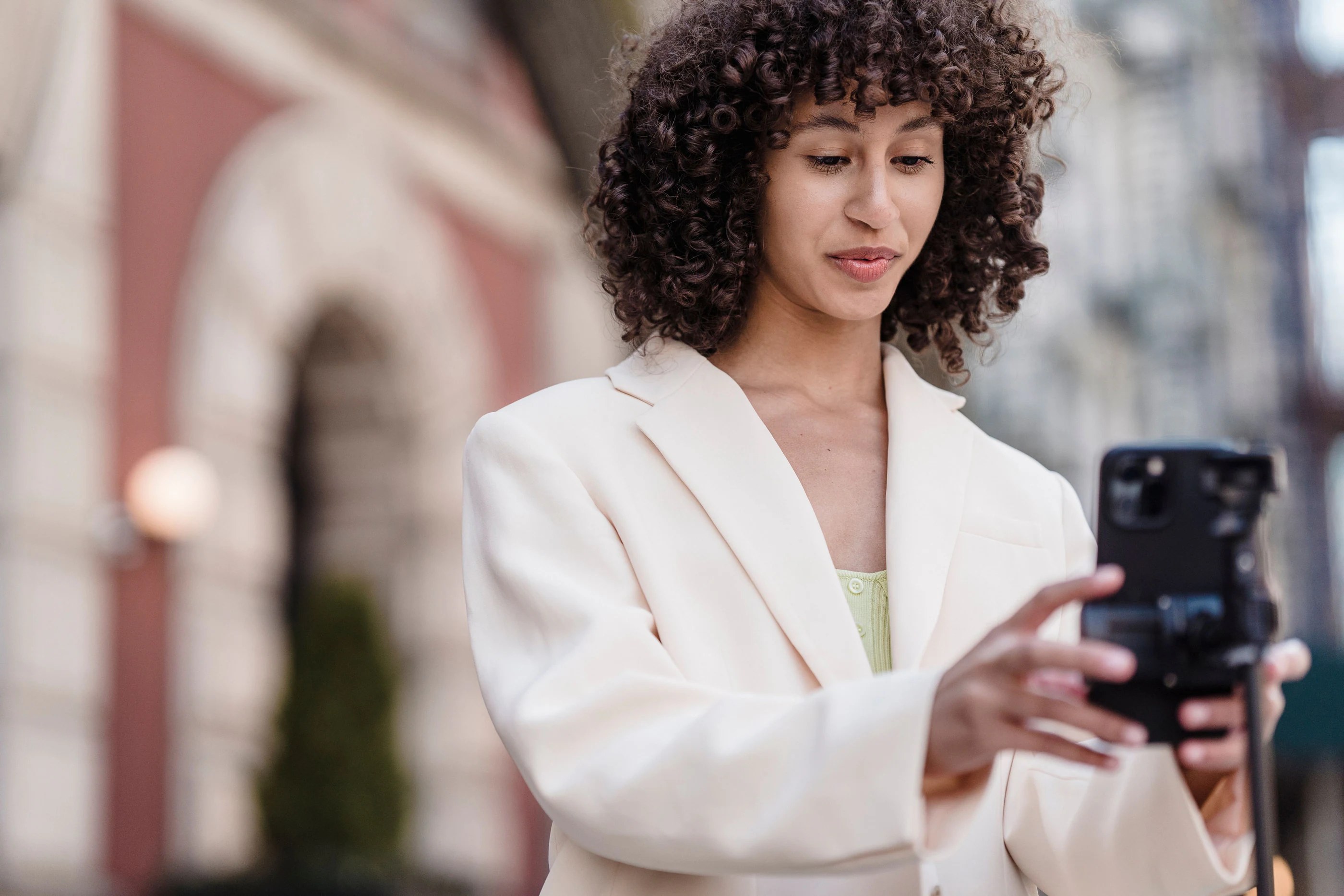 A creator filming herself on a phone on a city street