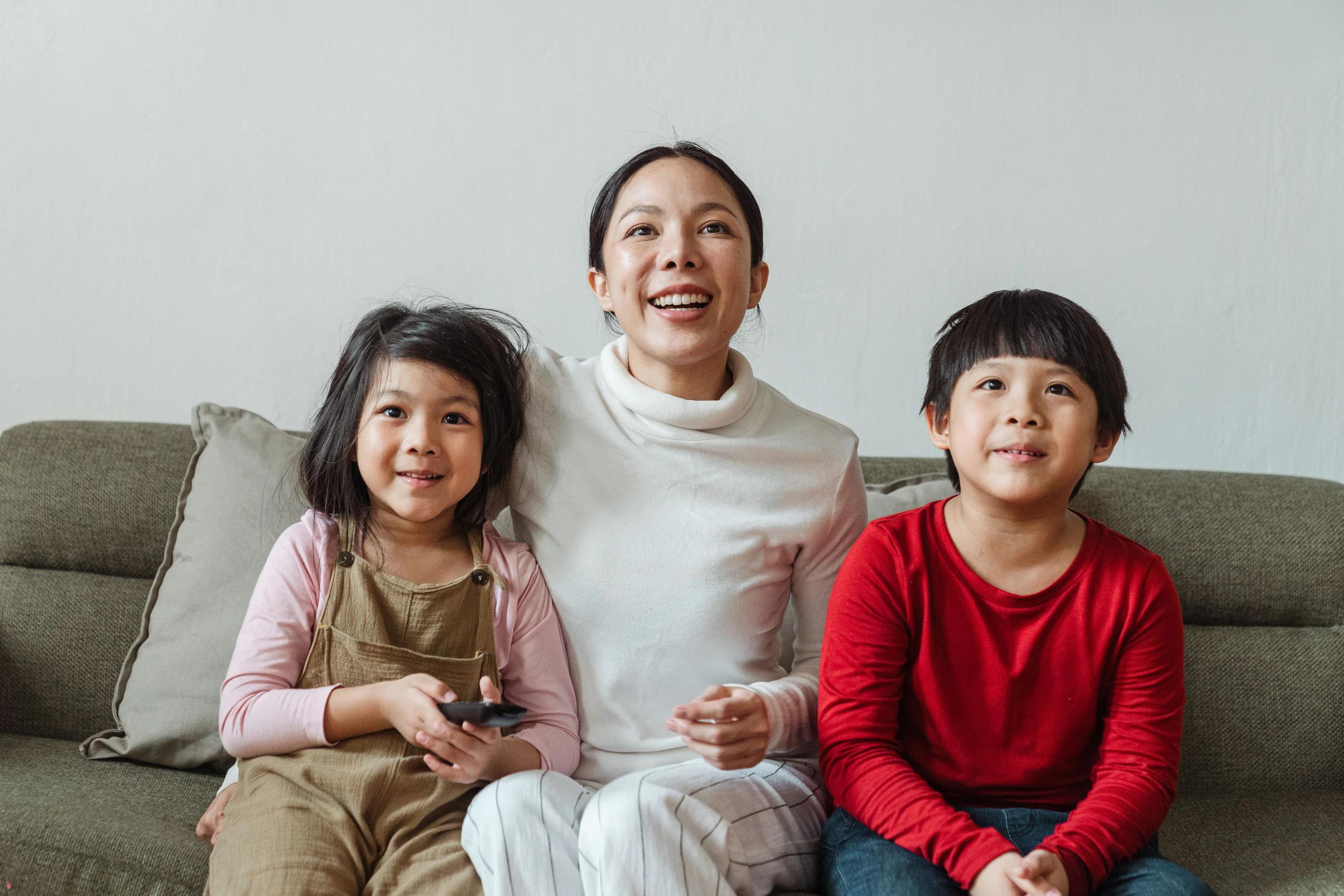 A family on a sofa watching television together