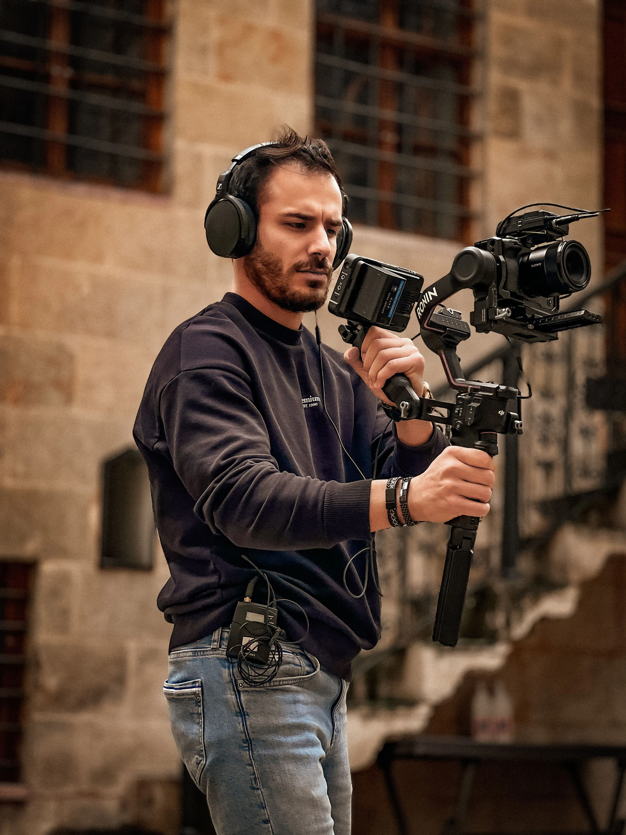 A filmmaker with a camera on a gimbal in warm light