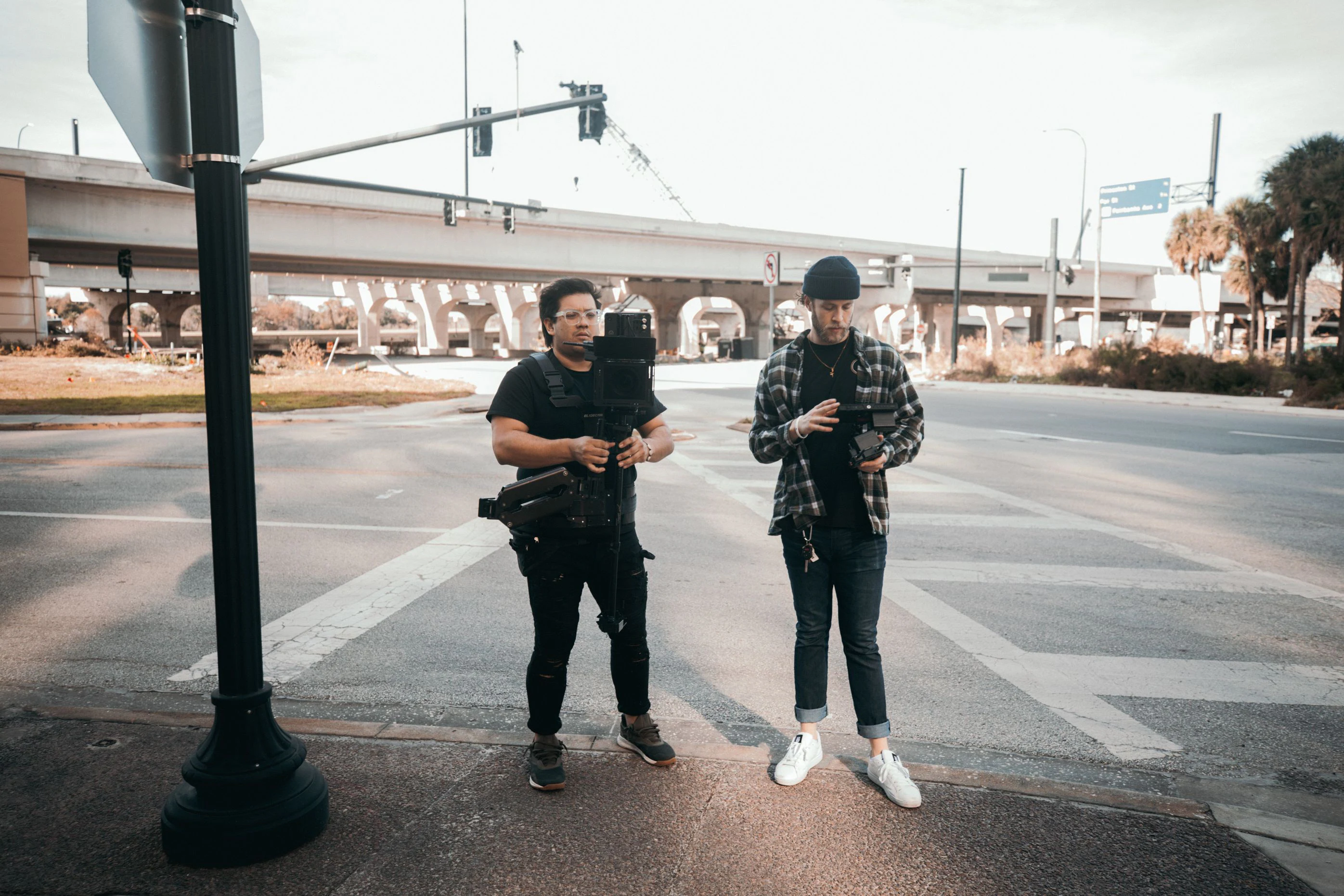 Two filmmakers with camera gear on an urban street