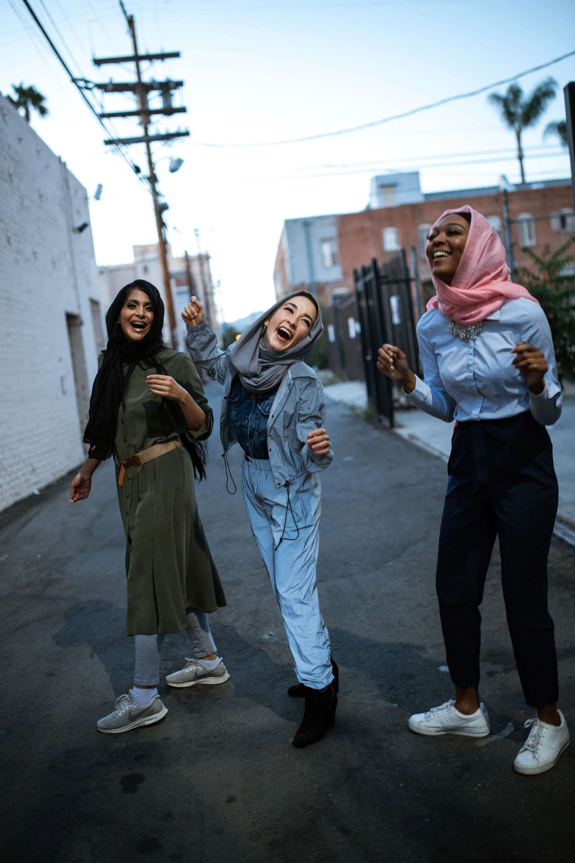 Three women laughing on a city street