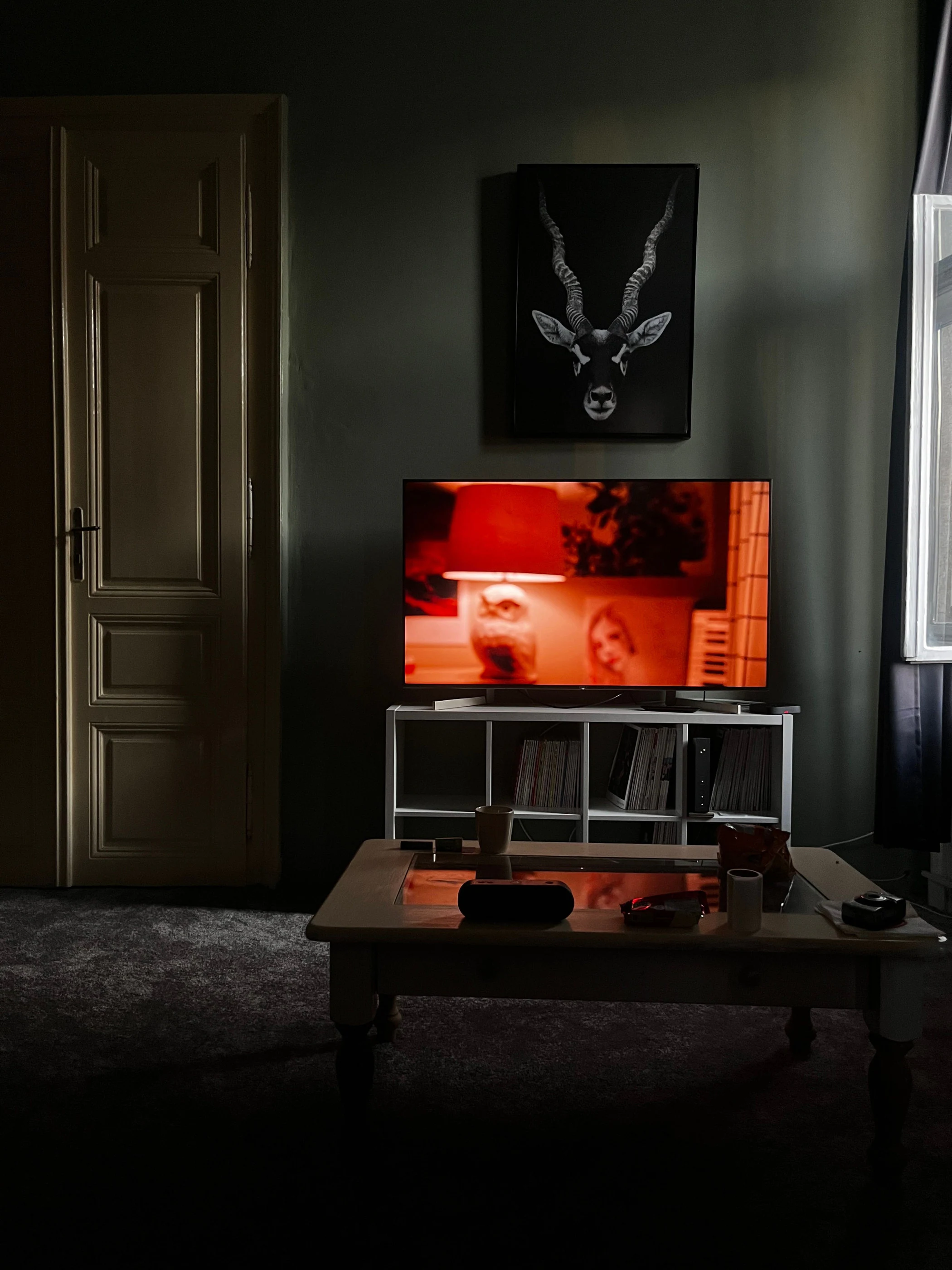 A television glowing in a dark living room